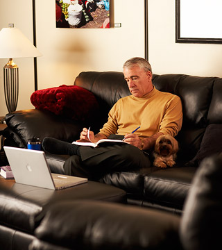 man on couch with a computer