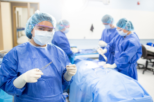 Nursing students working on a patient in room