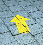 yellow arrow on brick path