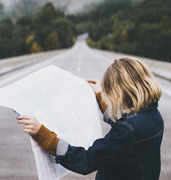 woman on road looking at map 