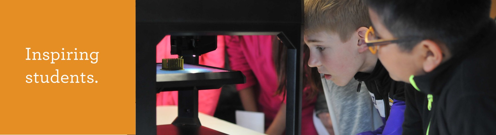 Inspiring students. Young students looking into microscope