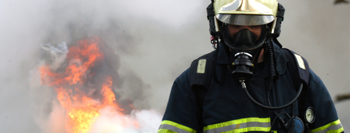 Firefighter in mask walking away from fire
