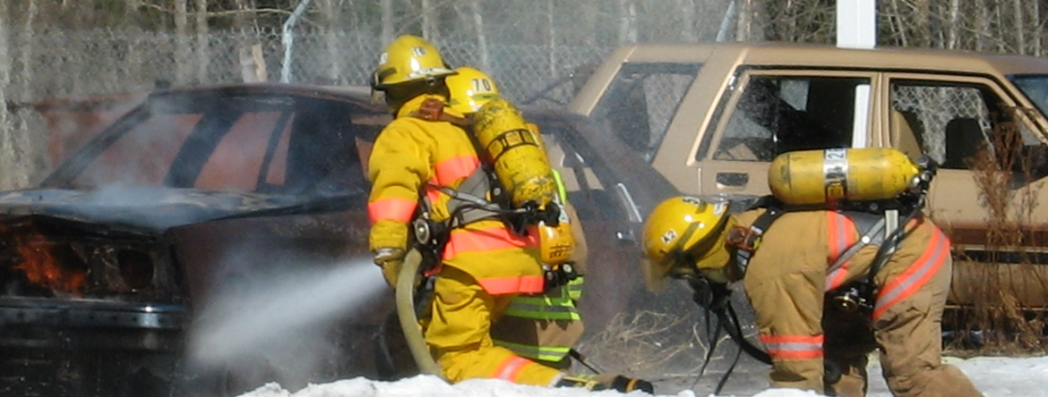 Two firefighters putting out car fire