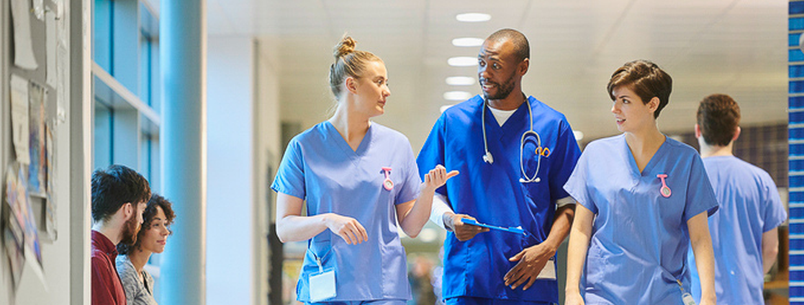 Health Care Workers Wearing Scrubs walking in hospital