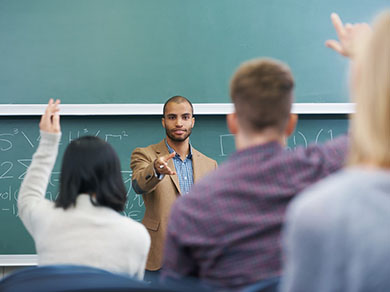 Young male instructor in front of high school class 