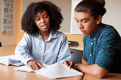 instructor with teen boy reviewing papers for Concurrent Enrollment coursework