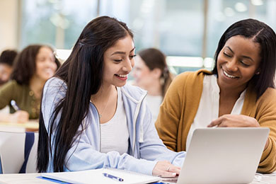 female instructor with teen girl and open laptop in concurrent coursework