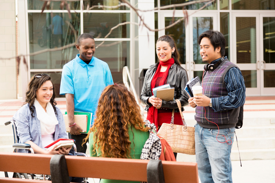 students having a conversation outside of campus building